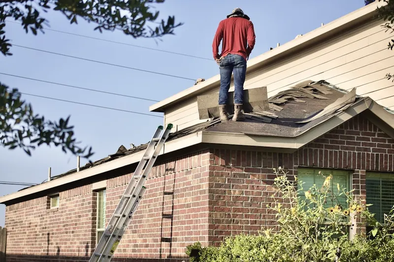 Professional roofer working on a residential roof in Fairington